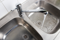 A sink with water running down the drain.