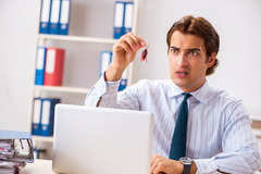 A person in professional attire holding a bug and looking disgusted.